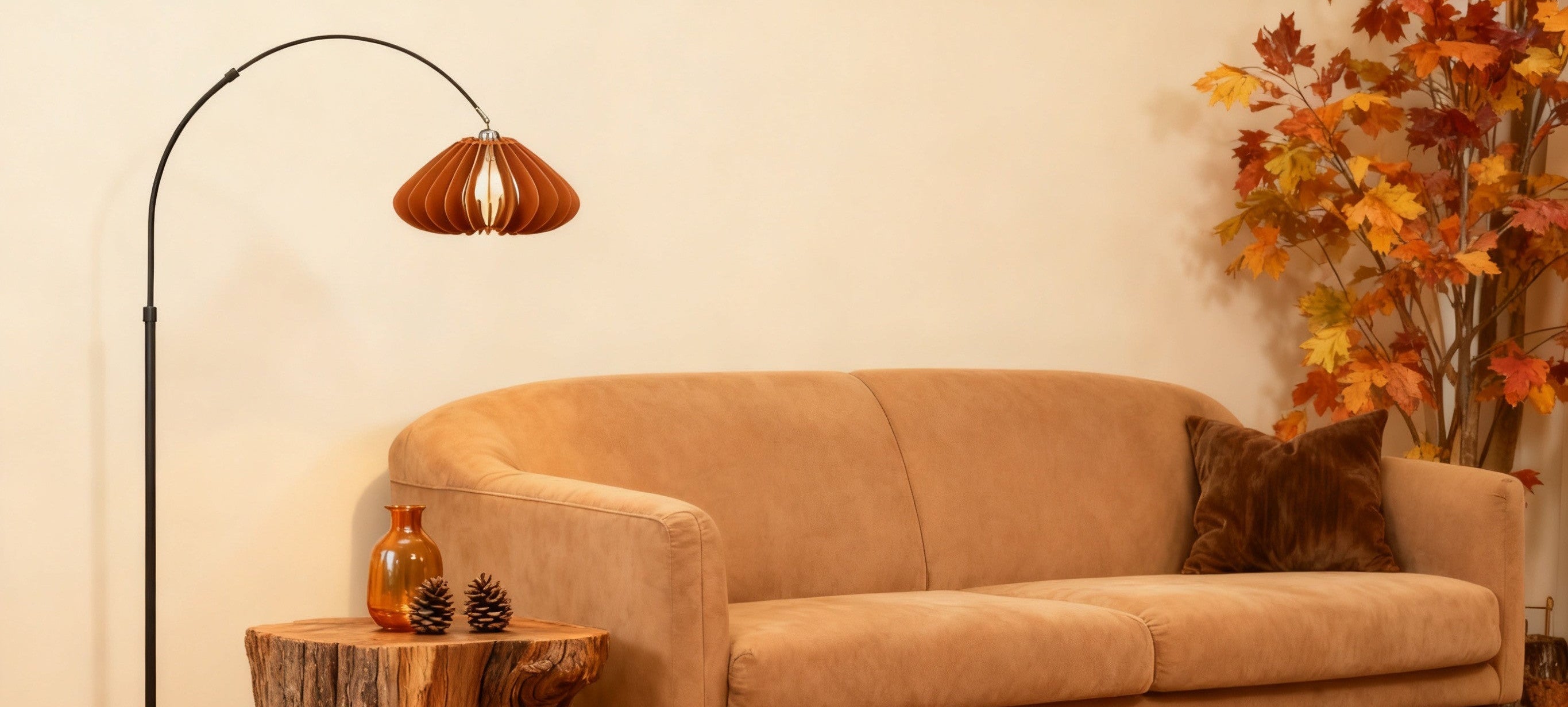 Beige sofa in a room with a Homira pumpkin floor lamp, decorative tree stump, and autumn-themed decorations.