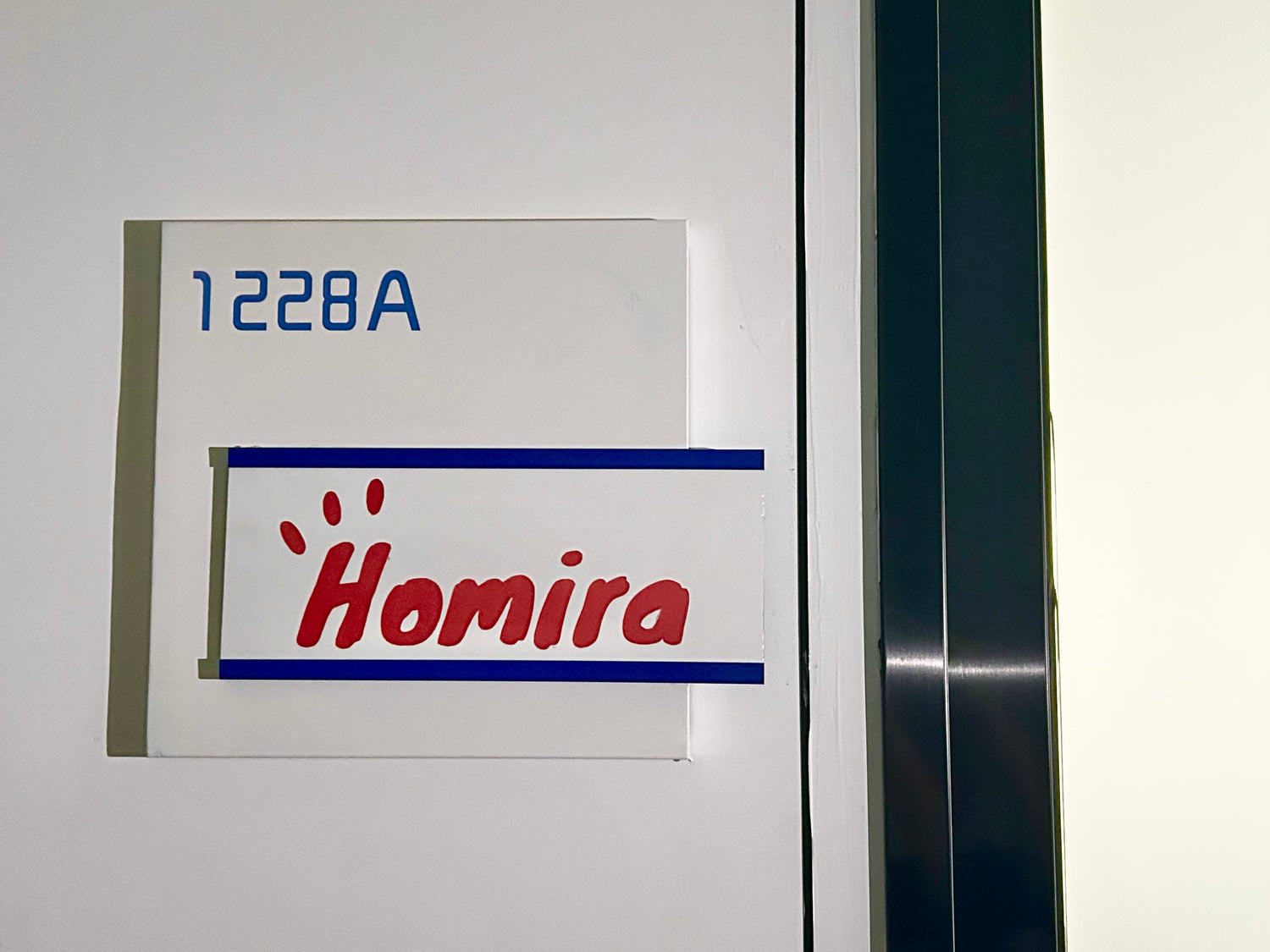 Door with a sign displaying the 'Homira' logo.