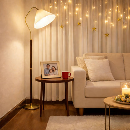 Cozy living room with a beige sofa, Homira fabric floor lamp, and decorative string lights.