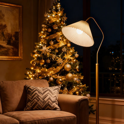 Decorated Christmas tree in a living room with a brown couch and a Homira floor lamp.
